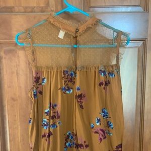 This is a tan floral shirt with a mesh dotted top. The size is XL.